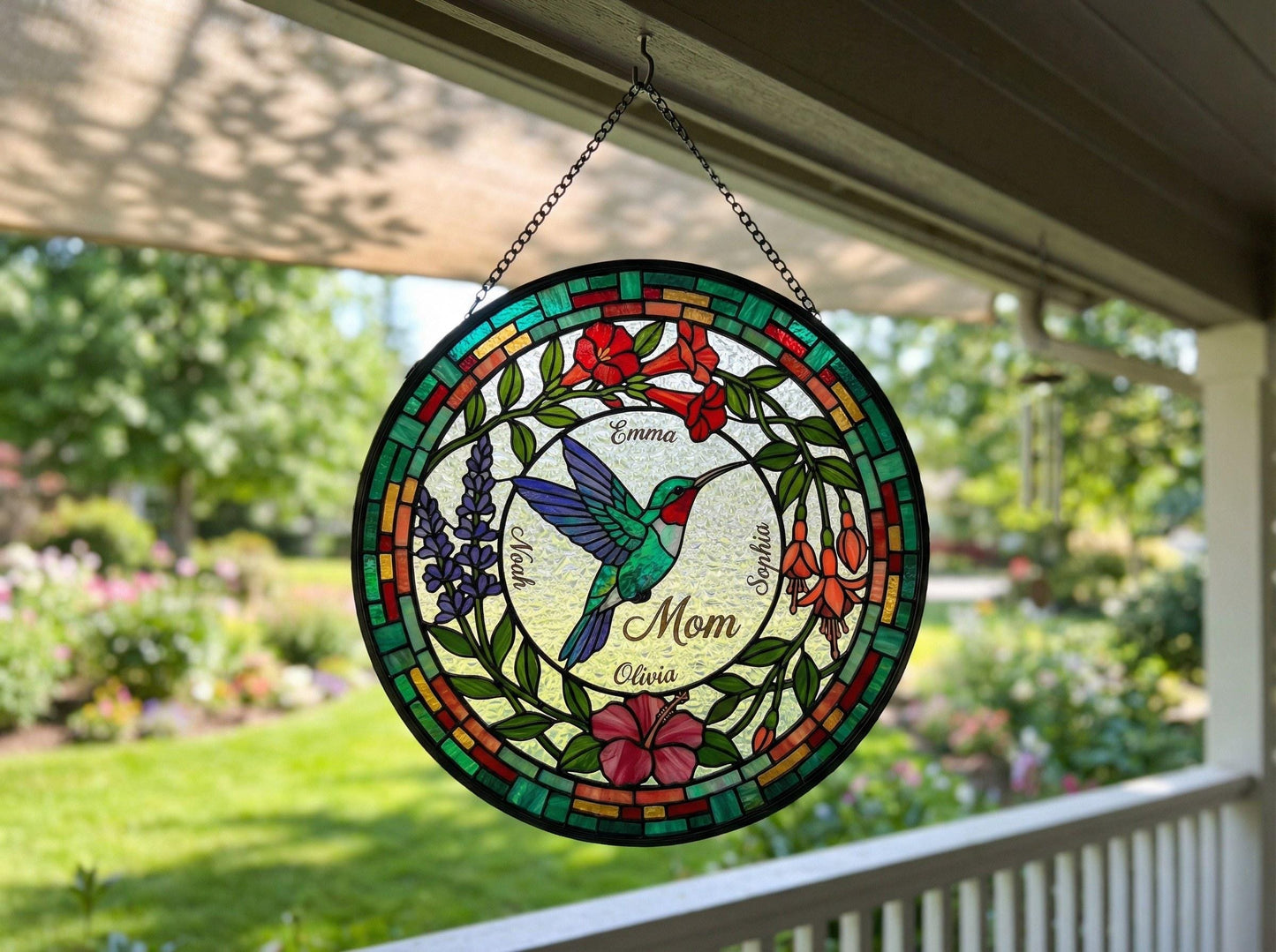 Close-up detail of emerald and ruby jewel-toned hummingbird with birth flower petals on suncatcher
