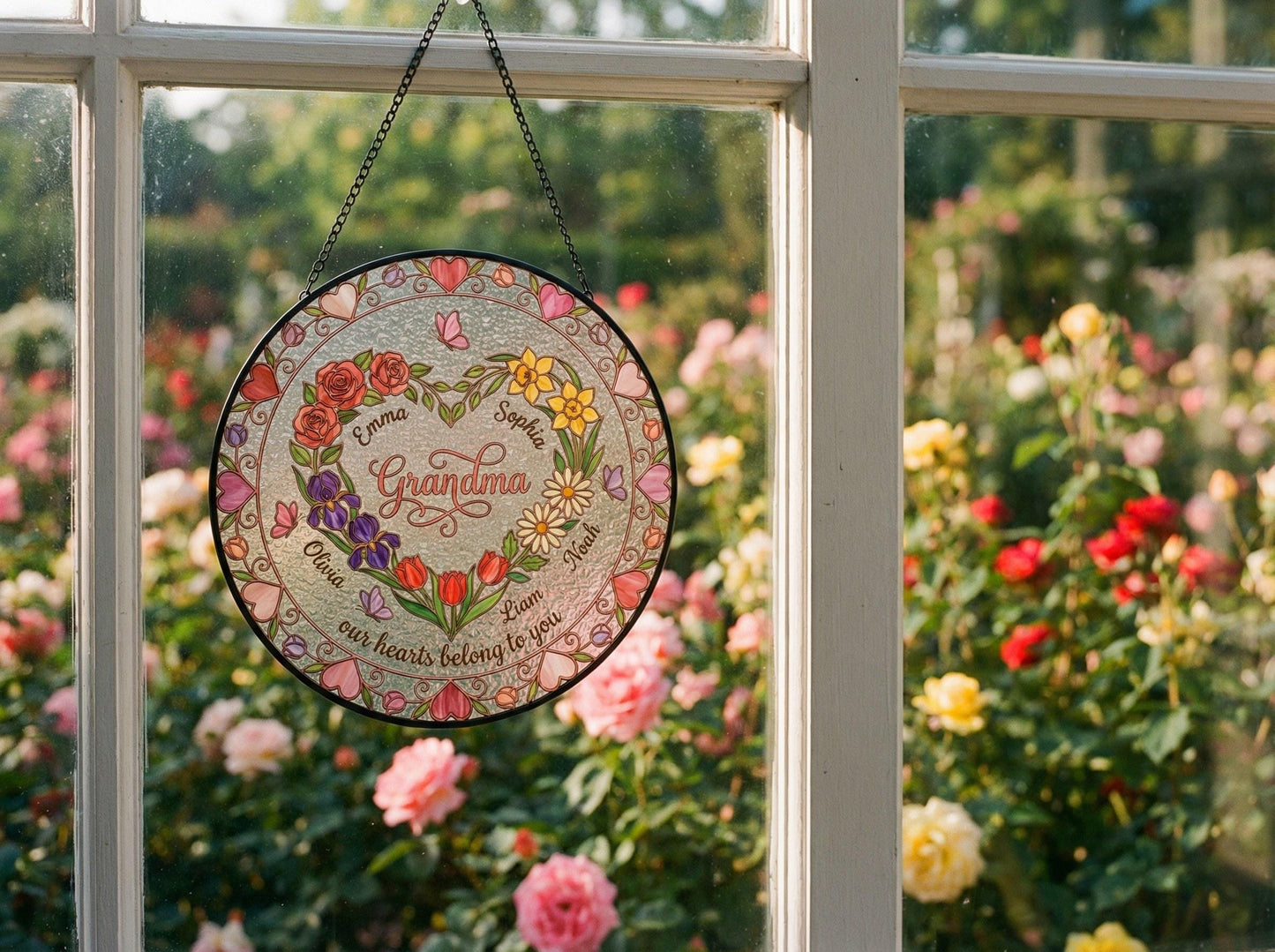 Hand holding 6-inch personalized heart garden suncatcher showing actual size with transparent glass and birth flower design