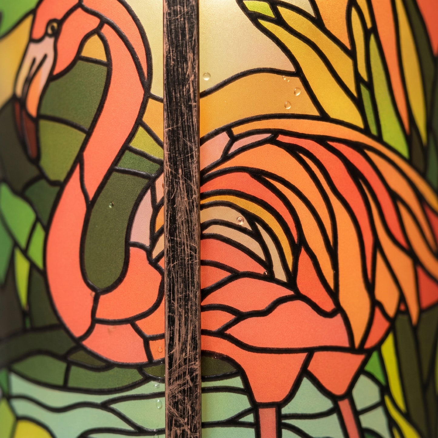 Close-up of the flamingo stained-glass-style panel, with the brushed bronze rib of the lantern frame
